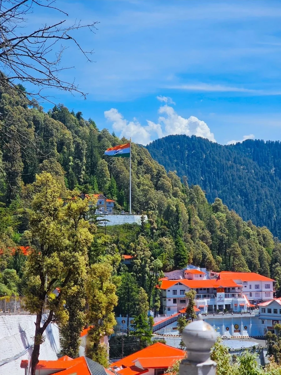 Dalhousie town in Himachal Pradesh — colonial-era rooftops on the forested hillside below the Subhash Chowk flagpole